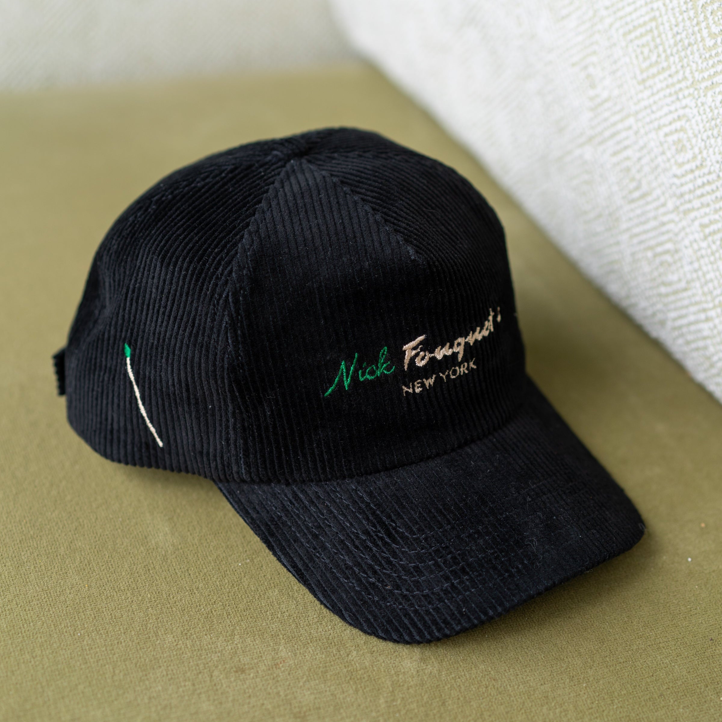 Black cap with embroidery on a beige surface