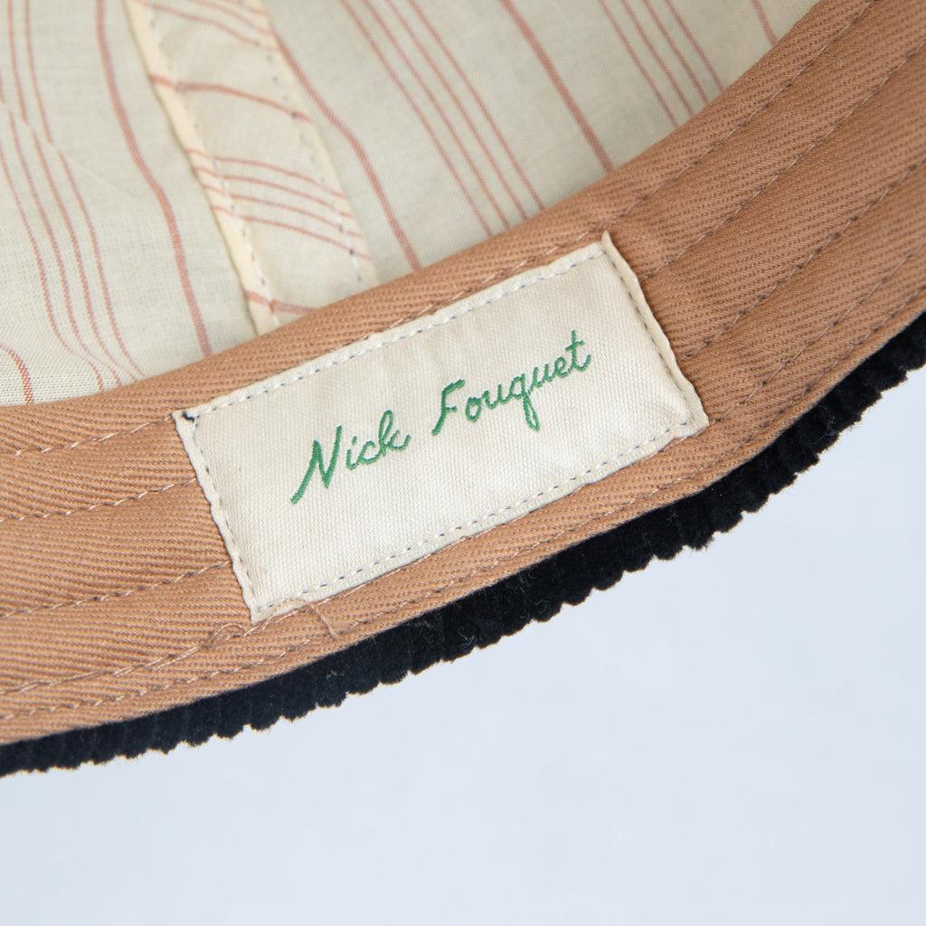Close-up of a label with 'Nick Fouquet' text on the ballcap interior.